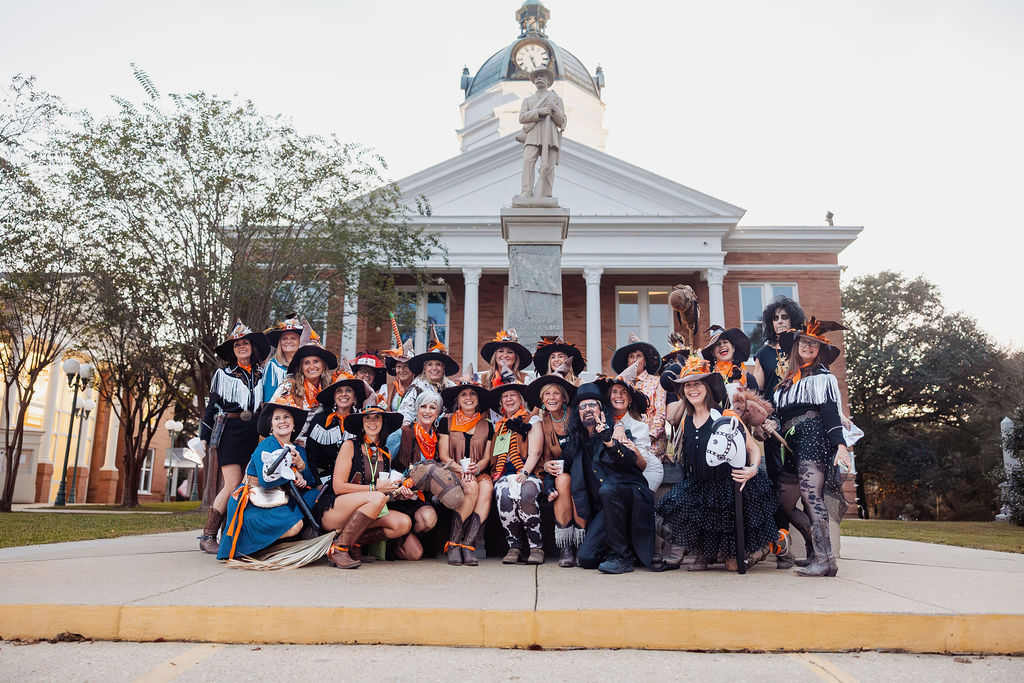 Costumed witches riding bikes down the street at The Witches Ride of St. Francisville